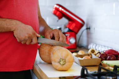 Erkek eli yemek taşır. Mutfakta sebze pişirir.