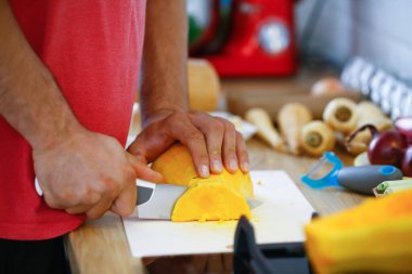 Erkek eli yemek taşır. Mutfakta sebze pişirir.