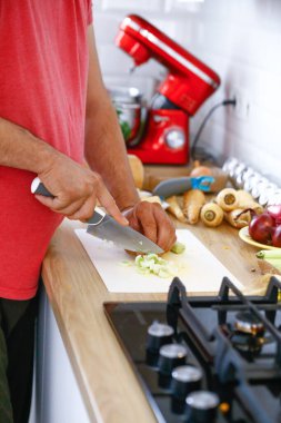 Erkek eli yemek taşır. Mutfakta sebze pişirir.