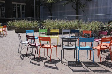 Yukardan, parlak zeminde modern turuncu sandalyeli dairesel beyaz masa resmi