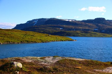 Dağlar arasında parlak gökyüzü ve parlak renkleri olan muhteşem bir göl görüntüsü. Dağlar, maceralar ve doğayı ve ruhu keşfetmek için ideal bir görüntü..