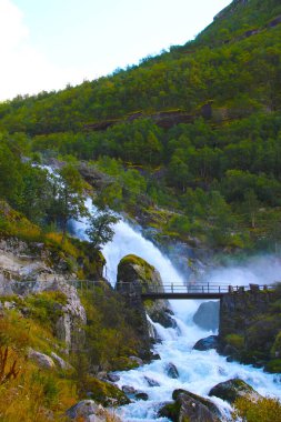 Dağların arasında beyaz suyu olan bir şelale. Egzotik yerlere seyahat etmeyi seviyorsanız ve şelaleleri, gölleri ve buzulları seviyorsanız ideal..