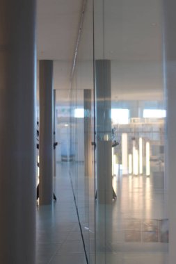 Koridor, sütun, yansımalar, ışık tüpleriyle aydınlatma. Basit malzemelerle dolu minimalist bir koridor görüntüsü. Yeni serginizi bir sanat galerisi ya da müze bekleme salonunda sergilemek için ideal.