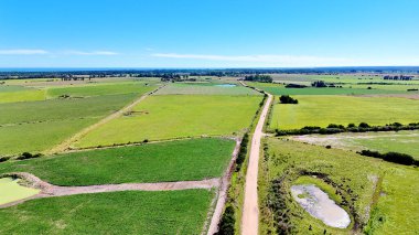Güneşli bir günde ekilen tarlalar arasındaki toprak yolun havadan görünüşü. Tarımsal makine satıcıları veya ekinlerin yetiştirildiği tarla ve çiftliklerin sahipleri için ideal.