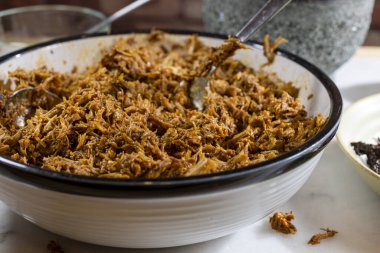 Pişirme ve işleme kırmızı ançolu biber ezmesi ve domuz eti ile beyaz mermer kesim tahtası üzerinde domuz eti çekti.