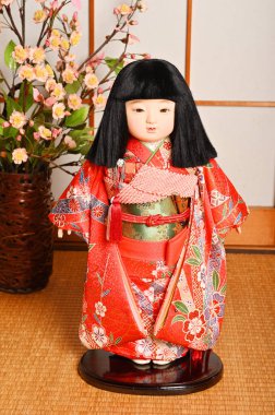 Ichimatsu bebeği önünde duruyor.