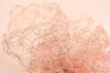 Yapay çiçeklerin arkasındaki dantel desen.