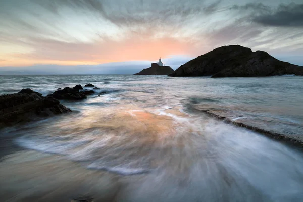 stock image Sunrise over Mumbles lighthouse in Swansea Bay, South Wales U