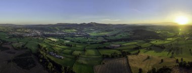 Güney Galler 'deki en yüksek Penyfan ve Corn Du tepelerine bakan Brecon Beacons üzerinde günbatımının panoramik görüntüsü