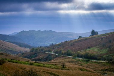 Storm clouds over Cribarth mountain and road through the Swansea Valley heading to Brecon town in South Wale clipart