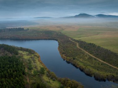 Güney Galler 'deki Brecon Beacons Ulusal Parkı' nın Kara Dağ bölgesinde ejderha nefesiyle kaplanmış Usk rezervuarı ve Fan Brycheiniog 'un hava manzarası.