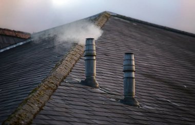 İki galvanizli metal bacanın önden görünüşü kayrak kanoyu tüketir.