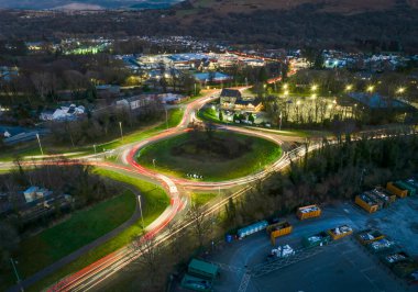 Editör Swansea, Wales - 31 Mart 2025: Ystradgylais, Güney Galler 'deki bir kavşakta ışık yollarının uzun pozlu drone fotoğrafı