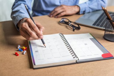 İş adamı ajandası takvimi ve hatırlatıcı ajanda evde çalışan erkekler masalarındaki günlüklerinde günlük randevular ve tatil seyahat günlükleri planlıyorlar. takvim anımsatma olayı kavramı .