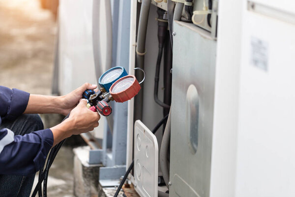 Technician is checking air conditioner ,measuring equipment for filling air conditioners.