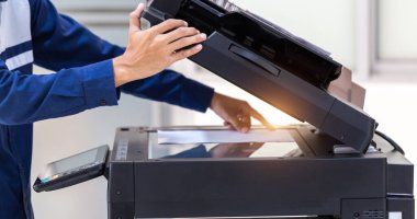 İşadamı, yazıcı fotokopi ağı panelindeki düğmeye basar, ofis konseptinde fotokopi üzerinde çalışır, yazıcı, kağıt tarama ve kopyalama için ofis çalışanı ekipmanıdır.