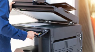İşadamı, yazıcı fotokopi ağı panelindeki düğmeye basar, ofis konseptinde fotokopi üzerinde çalışır, yazıcı, kağıt tarama ve kopyalama için ofis çalışanı ekipmanıdır.