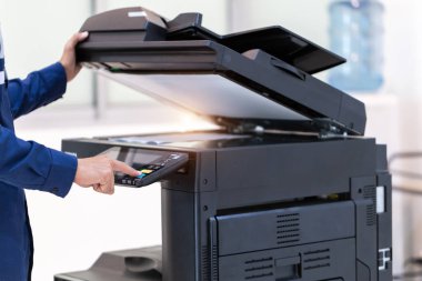İşadamı, yazıcı fotokopi ağı panelindeki düğmeye basar, ofis konseptinde fotokopi üzerinde çalışır, yazıcı, kağıt tarama ve kopyalama için ofis çalışanı ekipmanıdır.