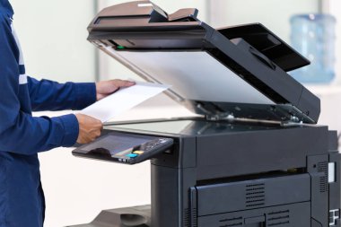 İşadamı, yazıcı fotokopi ağı panelindeki düğmeye basar, ofis konseptinde fotokopi üzerinde çalışır, yazıcı, kağıt tarama ve kopyalama için ofis çalışanı ekipmanıdır.