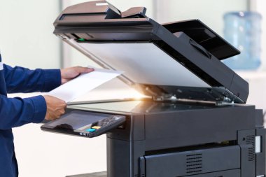 İşadamı, yazıcı fotokopi ağı panelindeki düğmeye basar, ofis konseptinde fotokopi üzerinde çalışır, yazıcı, kağıt tarama ve kopyalama için ofis çalışanı ekipmanıdır.