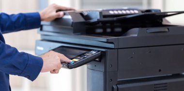 İşadamı, yazıcı fotokopi ağı panelindeki düğmeye basar, ofis konseptinde fotokopi üzerinde çalışır, yazıcı, kağıt tarama ve kopyalama için ofis çalışanı ekipmanıdır.