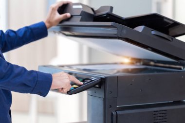 İşadamı, yazıcı fotokopi ağı panelindeki düğmeye basar, ofis konseptinde fotokopi üzerinde çalışır, yazıcı, kağıt tarama ve kopyalama için ofis çalışanı ekipmanıdır.