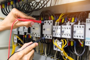 Elektrikçiler kontrol panelinde elektrik akımını test ediyorlar.