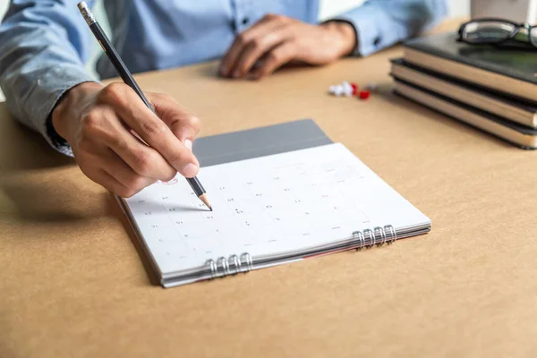 Businessman agenda calendar and reminder agenda work online at home men plan daily appointments and vacation travel journals in a diary at their desk . calendar reminder event concept .