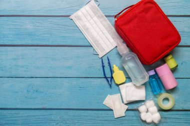 Ahşap arka planda tıbbi malzemeleri olan ilk yardım çantası taşıyan çocuk..