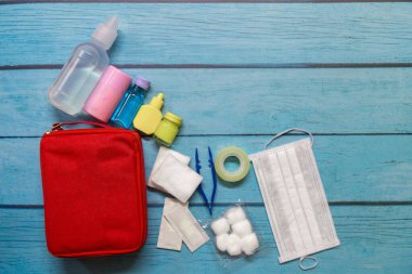 Ahşap arka planda tıbbi malzemeleri olan ilk yardım çantası taşıyan çocuk..