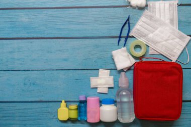 Ahşap arka planda tıbbi malzemeleri olan ilk yardım çantası taşıyan çocuk..