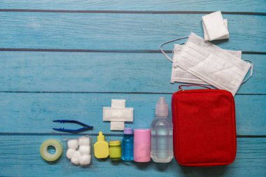 Ahşap arka planda tıbbi malzemeleri olan ilk yardım çantası taşıyan çocuk..