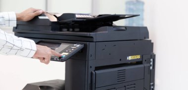 İşadamı, yazıcı fotokopi ağı panelindeki düğmeye basar, ofis konseptinde fotokopi üzerinde çalışır, yazıcı, kağıt tarama ve kopyalama için ofis çalışanı ekipmanıdır.