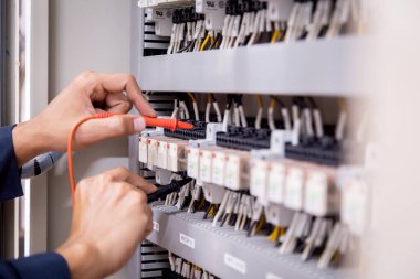 Elektrik mühendisi, devre kesici ve kablo tesisat sistemindeki elektrik akımını kontrol etmek için ölçüm ekipmanı kullanıyor. .