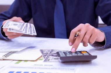 Hesaplamalar yapan muhasebeciye yaklaş. Tasarruf, finans ve ekonomi kavramı.