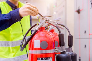 Profesyonel Mühendis yangın söndürücüyü kontrol ediyor. Pano kullanıyor veya Endüstriyel yangın kontrol sistemini kontrol ediyor. Yangın alarmı, yangın alarmı, yangın önleyici..