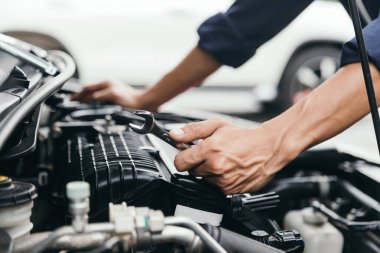 Otomobil tamircisi elleri ingiliz anahtarı, araba servisi ve bakımı ile bir araba motoru otomotiv atölyesini tamir ediyor..