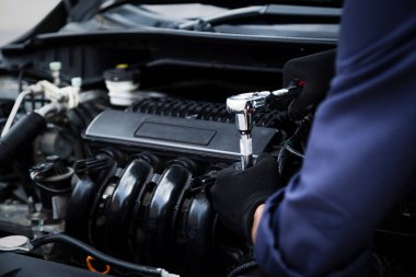 Otomobil tamircisi elleri ingiliz anahtarı, araba servisi ve bakımı ile bir araba motoru otomotiv atölyesini tamir ediyor.