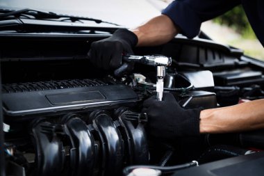Otomobil tamircisi elleri ingiliz anahtarı, araba servisi ve bakımı ile bir araba motoru otomotiv atölyesini tamir ediyor.