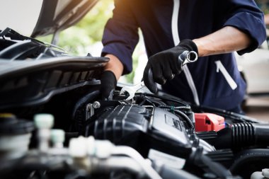 Otomobil tamircisi elleri ingiliz anahtarı, araba servisi ve bakımı ile bir araba motoru otomotiv atölyesini tamir ediyor.