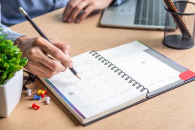İş adamı ajandası takvimi ve hatırlatıcı ajanda evde çalışan erkekler masalarındaki günlüklerinde günlük randevular ve tatil seyahat günlükleri planlıyorlar. takvim anımsatma olayı kavramı .