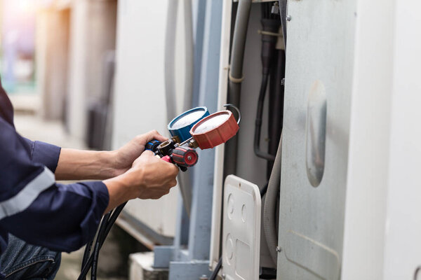 Technician is checking air conditioner ,measuring equipment for filling air conditioners.