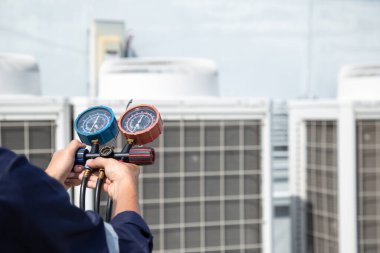 Teknisyen klimayı kontrol ediyor, klimaları, servis ve bakım klimalarını doldurmak için ölçüm aletleri kullanıyor. .