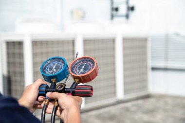 Teknisyen klimayı kontrol ediyor, klimaları, servis ve bakım klimalarını doldurmak için ölçüm aletleri kullanıyor. .