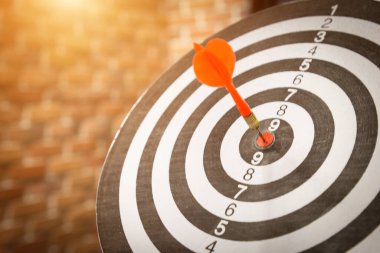 Kırmızı dart oku hedef tahtanın ortasına güneş ışığı klasik tarzıyla vuruyor, hedef pazarlama ve iş başarısı konsepti - görüntü.