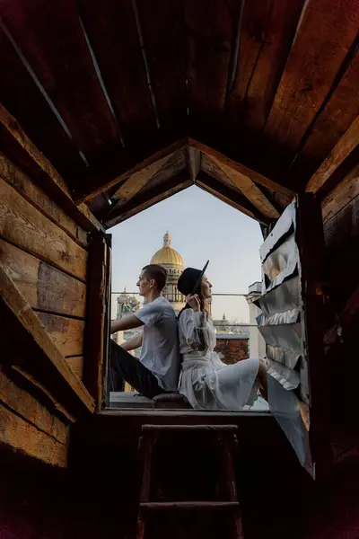 Bir adam ve bir kadın çatıda sarılıp öpüşüyorlar. Saint-Petersburg, Rusya 'da çatı. Isaacs Katedral Kubbesi 'ne bakın. Şehirde romantik bir çift buluşması..