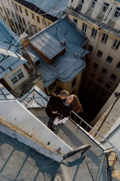 Bir adam ve bir kadın balkonda sarılıp öpüşüyorlar. Saint-Petersburg, Rusya 'da çatı. Şehirde romantik bir çift buluşması..