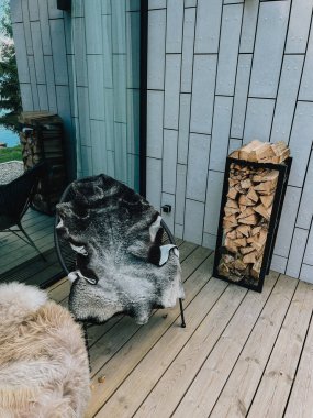 Teras ya da veranda, kır evinde sandalyeler, tatil oteli. Panoramik pencereli modern bir bina. Yazın göl, nehir ve ormanın yansıması..