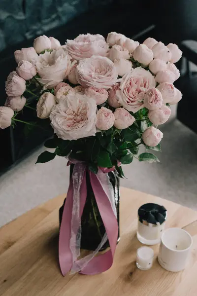 Güzel bir buket pembe çiçek. İçerideki vazoda şakayıklar.