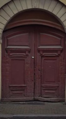 Yağmurlu bir havada sokakta yürüyen bir kadın. Beyaz gömlekli ve kot şortlu ıslak bir kadın. Yağmurlu bir şehirde esmer bir kız. Dikey